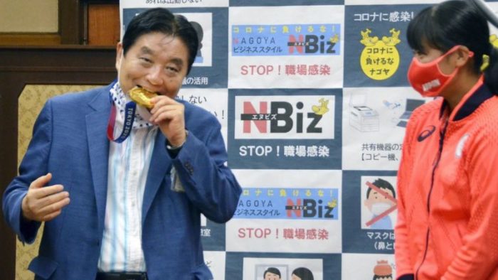 O prefeito Takashi Kawamura mordeu a medalha de Miu Goto, durante um evento (KYOTO/REUTERS)
