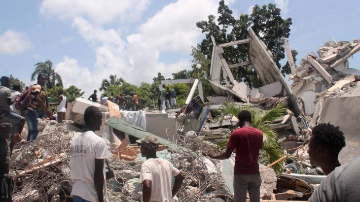 Pessoas vasculham os escombros do Manguier Hotel após o terremoto ocorrido ontem em Les Cayes, sudoeste do Haiti (STANLEY LOUIS / AFP)