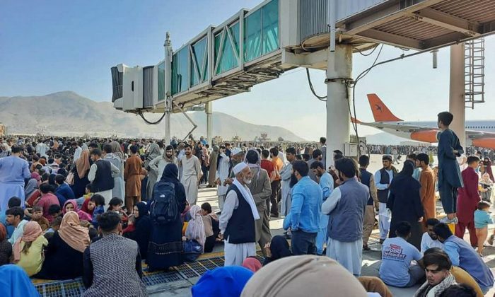 Afegãos ocupam pista do aeroporto de Cabul tentando embarcar em voos para o exterior após tomada de poder pelo Talibã (AFP)