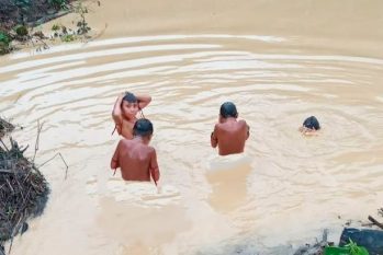 Crianças tomando banho em um rio com água contaminada por mercúrio, numa região da TI Yanomami conhecida como Xitei (Dário Kopenawa/Reprodução)