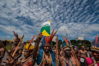 Indigenous holds up the Federal Constitution during a demonstration. (Fábio Nascimento/Greenpeace)