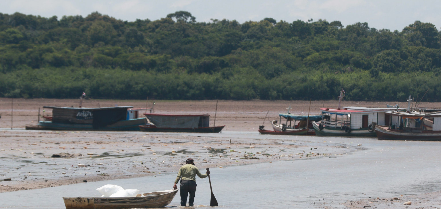 Fishermen need to drag boats for at least 15 minutes through the mud (Ricardo Oliveira/Cenarium Magazine)