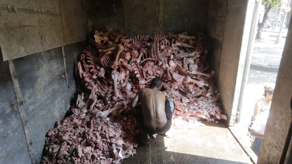 Image of people picking bones was published by Extra and shocked the country (Domingos Peixoto/Agência O Globo)