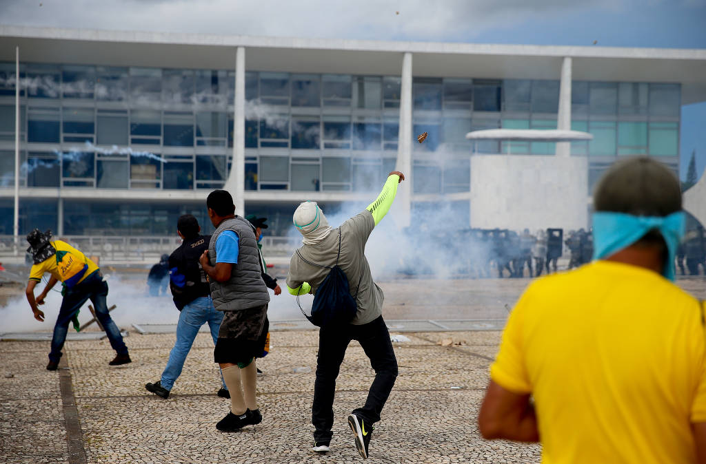 Manifestantes bolsonaristas jogam pedras na polícia durante protesto golpista. O Palácio do Planalto, o STF e o Congresso foram invadidos e depredados (Pedro Ladeira/Folhapress)