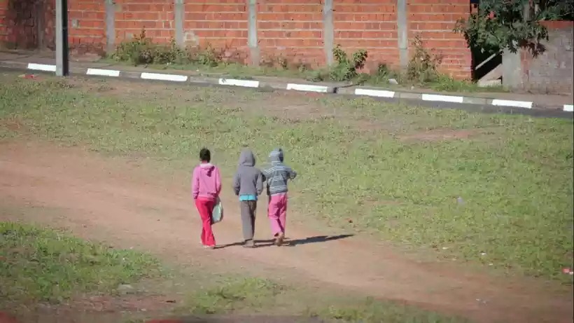 Crianças andam em estrada de terra. (Henrique Mourão/Divulgação)