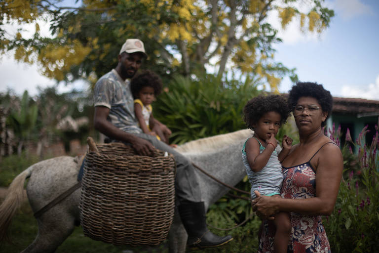 Moradores do quilombo Tabuleiro da Vitória, em Cachoeira (BA), são alvo de ameaças. Na foto, Joselene Oliveira, 44, Crispim dos Santos Machado, 26, com as filhas gêmeas Crystal e Jade, 2 (Rafaela Araújo/Folhapress)