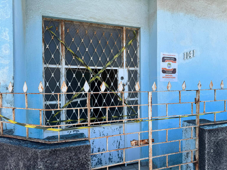 Casas com faixas de interdição em bairro de Maceió; algumas ainda estão com luzes acesas e portas entreabertas - (Josué Seixas/Folhapress)