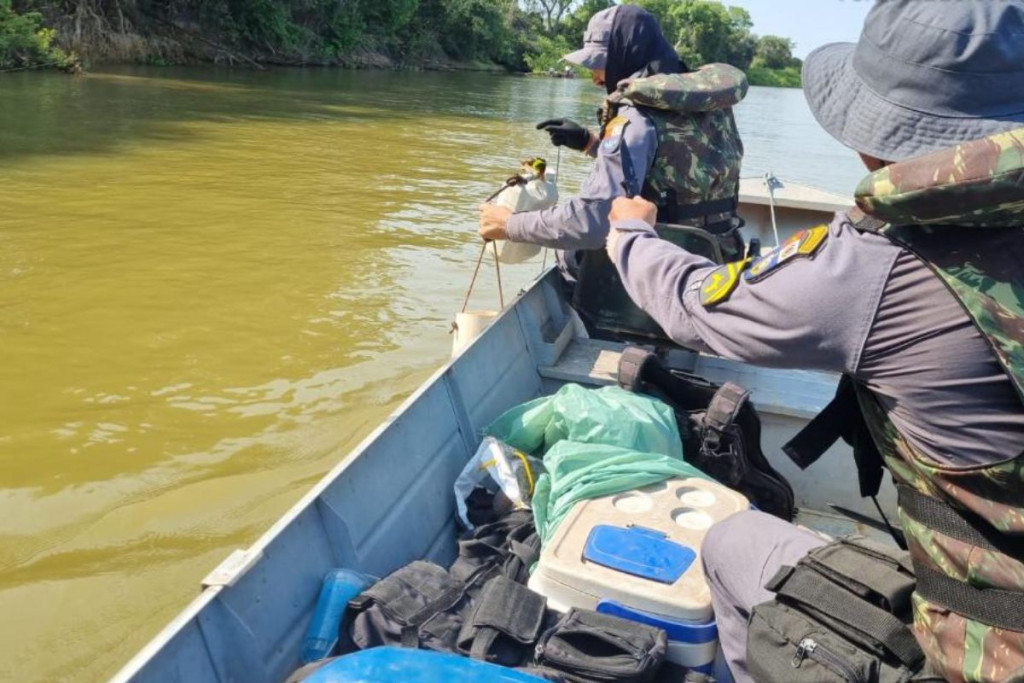 Fiscalização de policiais em barco durante vistoria em rio de MT.
