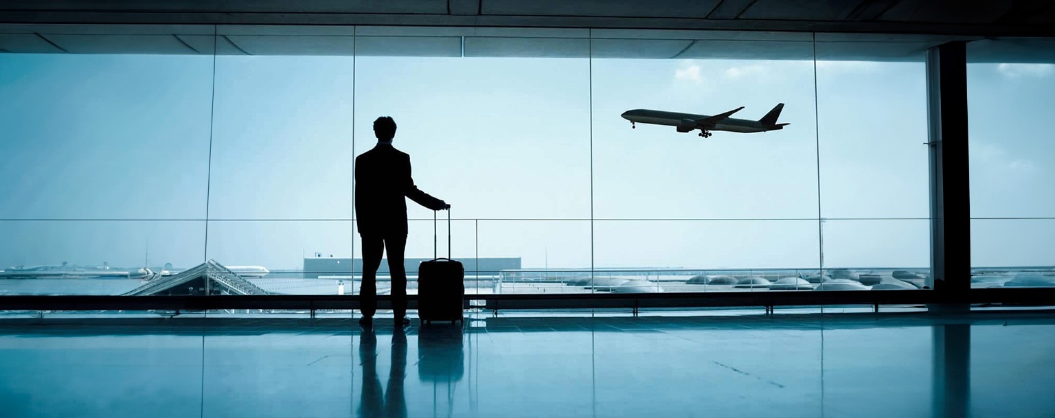 Homem em aeroporto vendo avião decolar (Reprodução/Shutterstock)