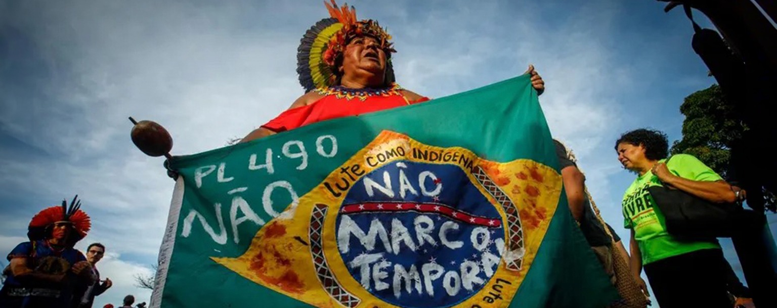 Indígena com a bandeira do Brasil contra o marco temporal (Brenno Carvalho/Agência O Globo)