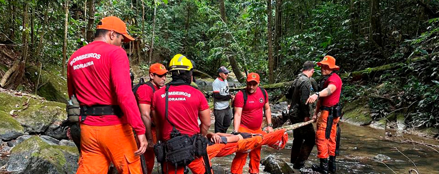 Momento em que bombeiros resgatam o pedreiro em maca, no meio da mata (Reprodução/CBMRR)